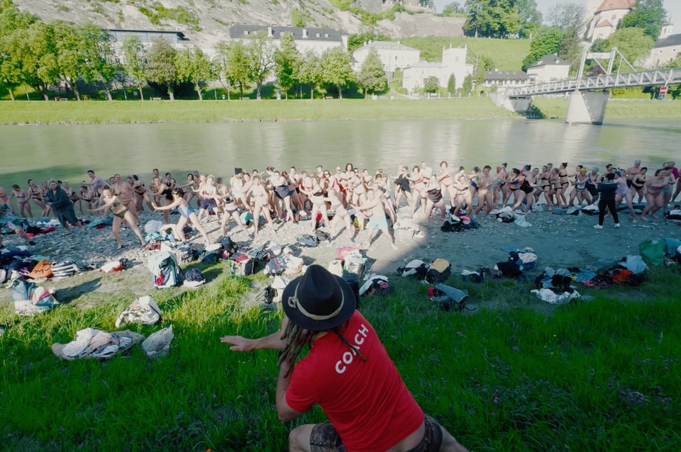 Daniel Fetz leitet eine große Eisbadegruppe am Ufer der Salzach in Salzburg an