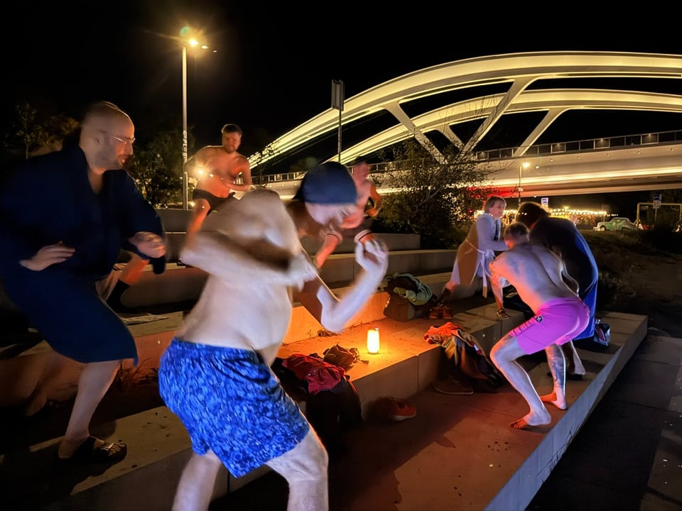 Teilnehmer wärmen sich nach dem Eisbad unter der Linzer Eisenbahnbrücke auf